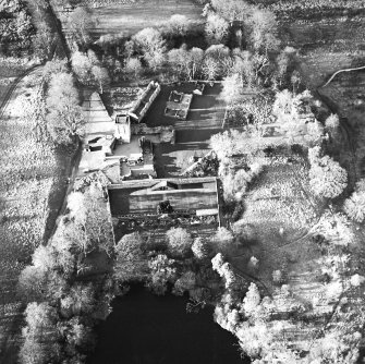 Oblique aerial view centred on the remains of the castle, chapel and tower, taken from the E.