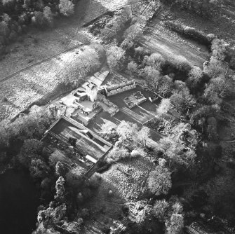 Oblique aerial view centred on the remains of the castle, chapel and tower, taken from the NE.