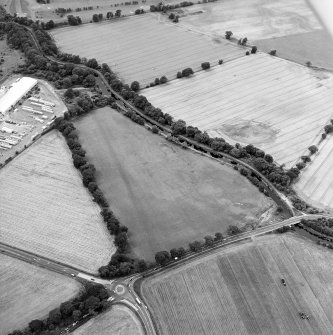 Oblique aerial view centred on the cropmarks of the Antonine Wall near Cadder, taken from the ESE.
