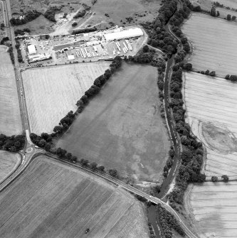 Oblique aerial view centred on the cropmarks of the Antonine Wall near Cadder, taken from the NE.