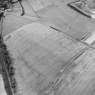 Oblique aerial view centred on the cropmarks of the Antonine Wall and the site of the Roman fortlet, taken from the SE.