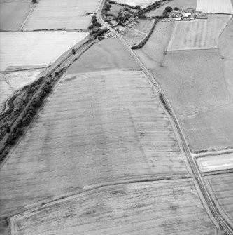 Oblique aerial view centred on the cropmarks of the Antonine Wall and the site of the Roman fortlet, taken from the ENE.