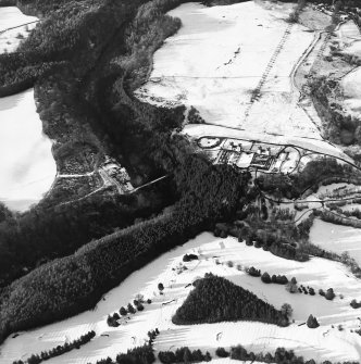 Oblique aerial view centred on the hunting lodge and ornamental gardens with the remains of a castle adjacent, taken from the SE.