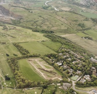 Oblique aerial view centred on the excavations at Dullatur Roman Camps with the Antonine Wall nearby, taken from the ESE