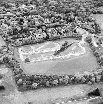 Oblique aerial view centred on the excavations at Dullatur Roman Camps, taken from the SSE