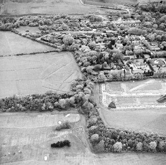 Oblique aerial view centred on the excavations at Dullatur Roman Camps with the Antonine Wall nearby, taken from the SSE