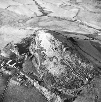 Oblique aerial view centred on the radio station and the remains of the fort with the quarry adjacent, taken from the SE.