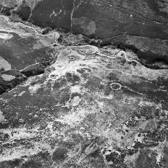 Oblique aerial view centred on the remains of sheepfolds, taken from the SSE.