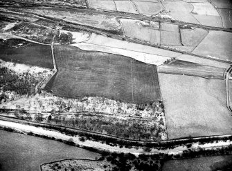 Oblique aerial view of the Antonine Wall and site of the fortlet at Seabegs Wood from the north, centred c. NS 8126 7927.