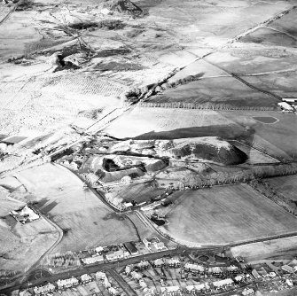 Oblique aerial view centred on the remains of the coal mine with a further coal mine, mineral railway and rig adjacent, taken from the SSE.