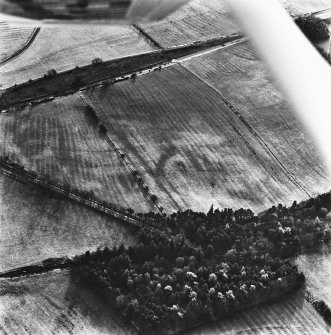 Loanhead and Slamannan Railway, oblique aerial view, taken from the N, with a cropmark enclosure in the centre, and rig covering most of the photograph. Slamannan Railway runs across the top.