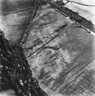 Loanhead and Slamannan Railway, oblique aerial view, taken from the W, with a cropmark enclosure in the centre, and rig across most of the photograph. Slamannan Railway runs across the top right-hand corner.