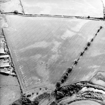Oblique aerial view centred on the cropmarks of the pits, rig and Roman temporary camps, taken from the NW.