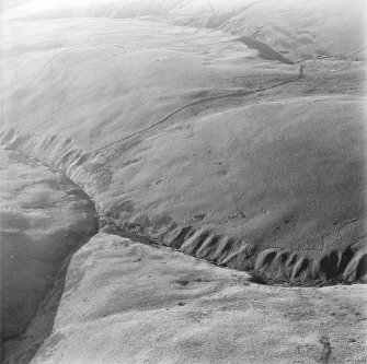 Oblique aerial photograph of shieling-huts and bank on west bank of the Second Inchna Burn (NS89NE 109) with head-dyke of neighbouring field-system (NS89NW 54.02) in background, from north-east.