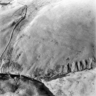 Oblique aerial photograph of shieling-huts and bank on west bank of the Second Inchna Burn (NS89NE 109) with head-dyke of neighbouring field-system (NS89NW 54.02) in background, from east.