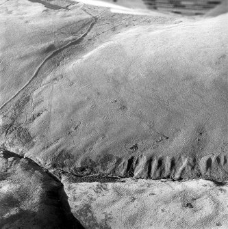 Oblique aerial photograph of shieling-huts and bank on west bank of the Second Inchna Burn (NS89NE 109) with head-dyke of neighbouring field-system (NS89NW 54.02) in background, taken from the ENE.