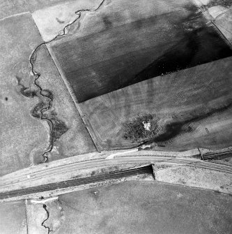 Oblique aerial view centred on the soilmarks of the Roman fortlet, taken from the NW.