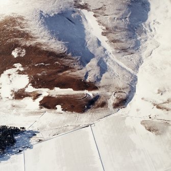 Oblique aerial view centred on the remains of the forts and enclosures, taken from the ESE.