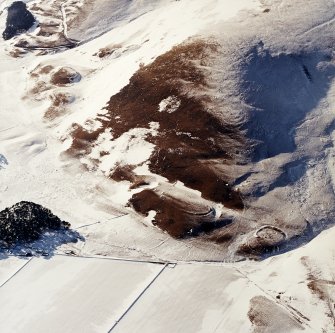 Oblique aerial view centred on the remains of the forts and enclosures with the remains of the settlements, rig, possible cultivation terraces and enclosure adjacent, taken from the E.