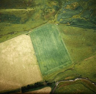 Oblique aerial view centred on the cropmarks of the Roman temporary camp with the remains of the fort and settlement adjacent, taken from the SE.