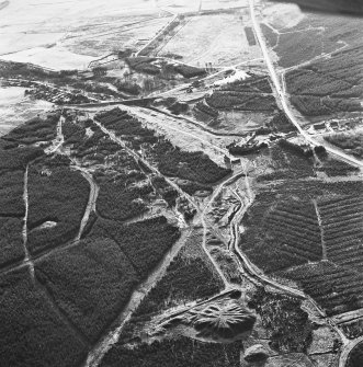 Wilsontown, oblique aerial view, taken from the NE, showing the bings of two coal mines at the bottom, and the remains of ironworks, workers' rows, lime kilns, coke ovens and buildings across the remainder of the photograph.