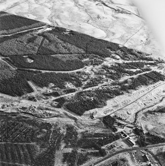 Wilsontown, oblique aerial view, taken from the ESE, showing the remains of workers' rows in the centre left of the photograph, and the ruined public house and shop, and a large area of bell pits, in the centre.