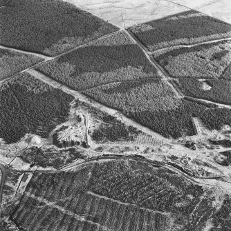 Wilsontown, oblique aerial view, taken from the E, showing the bings of two coal mines in the centre left of the photograph, and the remains of a workers' row, and an area of bell pits, in the centre right.