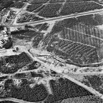 Wilsontown, oblique aerial view, taken from the E, showing the the remains of workers' rows and buildings, and bell pits, across the bottom half of the photograph.