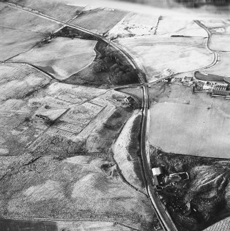 Haywood, Droveloan and Greenbank, oblique aerial view, taken from the ESE, showing Haywood village with the remains of miners' rows and a farmstead in the centre of the photograph, a cottage and the two bings of a coal mine adjacent to the dismantled railway, and Droveloan cottage, in the bottom right-hand corner, and an area of rig at Greenbank in the centre right.