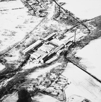 Oblique aerial view centred on the paper mill, taken from the SE.