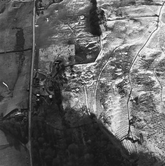 Oblique aerial view centred on the remains of the settlement, sheepfolds, field clearance heap and quarry and the post office, taken from the NE.