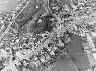 General oblique aerial view centred on the remains of the fort with the churches and churchyard adjacent, taken from the S.
