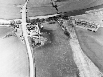 Oblique aerial view centred on the road bridge and the remains of the motte and railway viaduct, taken from the ENE.