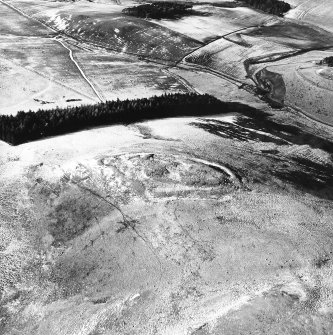 Snaip Hill, oblique aerial view, taken from the NE, centred on the remains of fort, with an enclosure and possible hut circle.