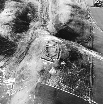 Cow Castle, oblique aerial view, taken from the N, centred on a settlement site, with a sheepfold to the left of the photograph.