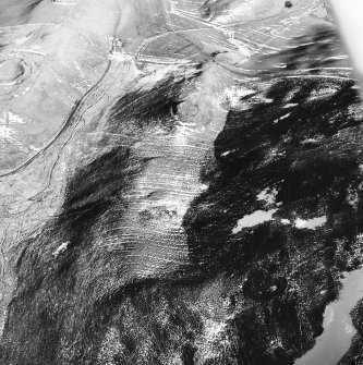 Langloch Knowe, oblique aerial view, taken from the W, centred on cultivation terraces and a fort, with another fort and settlement to the left of the photograph.