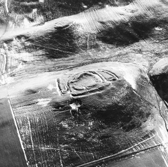 Cow Castle, oblique aerial view, taken from the NW, centred on a fort and settlement site, with Langloch Knowe fort and cultivation terraces to the top of the photograph.