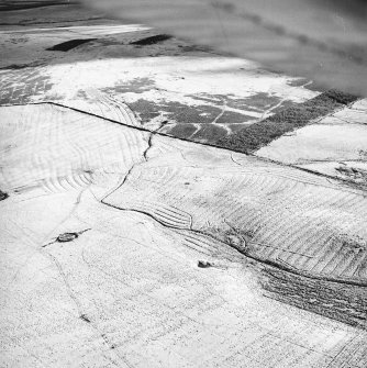 Morton Hill, oblique aerial view, taken from the NE, showing an area of rig and furrow cultivation across the photograph, and a sheepfold from in the left centre.