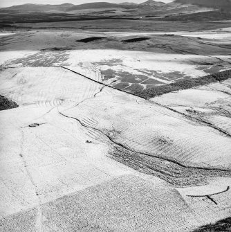 Morton Hill, oblique aerial view, taken from the N, showing an area of rig and furrow cultivation across the photograph, a sheepfold in the left centre, and a sheep shelter in the bottom right-hand corner.