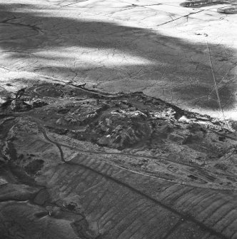 Tarbrax Shale-Oil Works, oblique aerial view, taken from the E, showing one massive bing of the shale-oil mine alongside a tramway in the centre of the photograph, with another tramway running up the right-hand side, and the remains of an engine house and dam, and an area of rig, at the bottom.