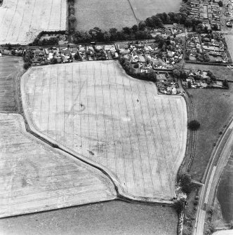 Muirhouses and Drum, oblique aerial view, taken from the WNW, centred on the cropmarks of a Roman Temporary Camp and possible souterrain. The cropmarks of an enclosure and possible coal pits are visible in the bottom left-hand corner of the photograph.