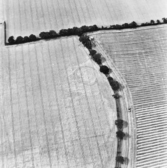 Raeburnfoot, oblique aerial view, taken from the NW, centred on the bank barrow. Raeburnfooot Roman Fort, and enclosures at Kiln Syke, are visible in the top half of the photograph.