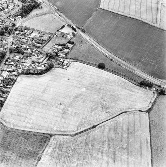 Muirhouses and Drum, oblique aerial view, taken from the N, centred on the cropmarks of a Roman Temporary Camp and possible souterrain. The cropmarks of an enclosure and possible coal pits are visible in the bottom half of the photograph.