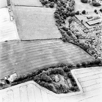 Grange Lodge and Drum Farm, oblique aerial view, taken from the ESE, centred on the cropmarks of a possible enclosure. A series of circular marks in the centre left of the photograph may represent coal pits. The Manse of Carriden is visible in the bottom centre.