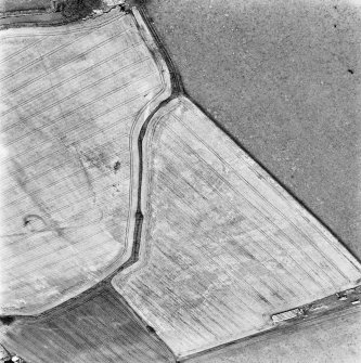 Drum and Muirhouses, oblique aerial view, taken from the SW, centred on the cropmarks of an enclosure and possible coal pits. The cropmarks of a Roman Temporary Camp and possible souterrain are visible in the right half of the photograph.