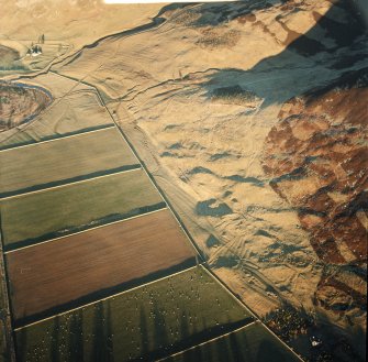 Oblique aerial view centred on the remains of the sheepfold, cairn and cist with the remains of the enclosure, scooped settlement, banks and enclosure adjacent, taken from the SW.