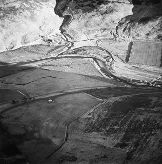 Oblique aerial view centred on the remains of the buildings, rig, cultivation terraces with the remains of the possible settlement and enclosure adjacent, taken from the NW.