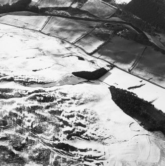 Oblique aerial view centred on the remains of the cultivation terraces, rig and sheepfold with the remains of the castle and settlement adjacent, taken from the ESE.