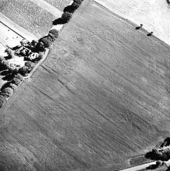 Old Harestanes, oblique aerial view, taken from the NNE, centred on cropmarks of ring-ditches, and a number of linear cropmarks. The cropmarks of the SW side of Castlecraig Roman temporary camp and an adjoining possible enclosure are also visible.