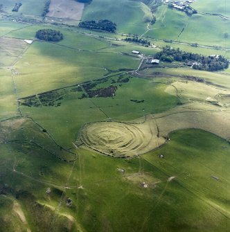 Oblique aerial view centred on the remains of the fort and linear earthwork with the remains of the linear earthwork and pit-alignment adjacent, taken from the ENE.